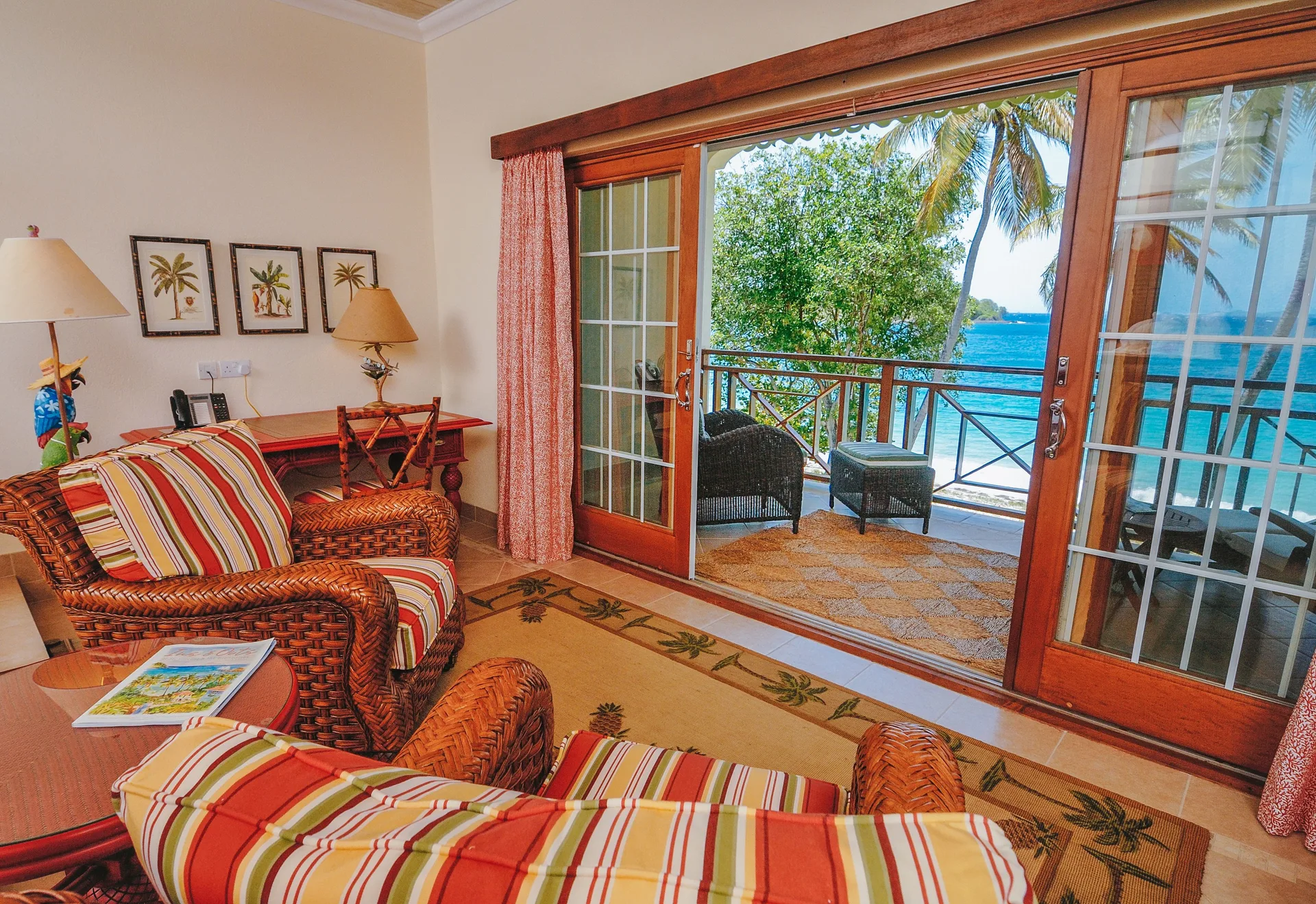 Beachfront room sitting area opening to an ocean-view balcony at Bequia Beach Hotel.