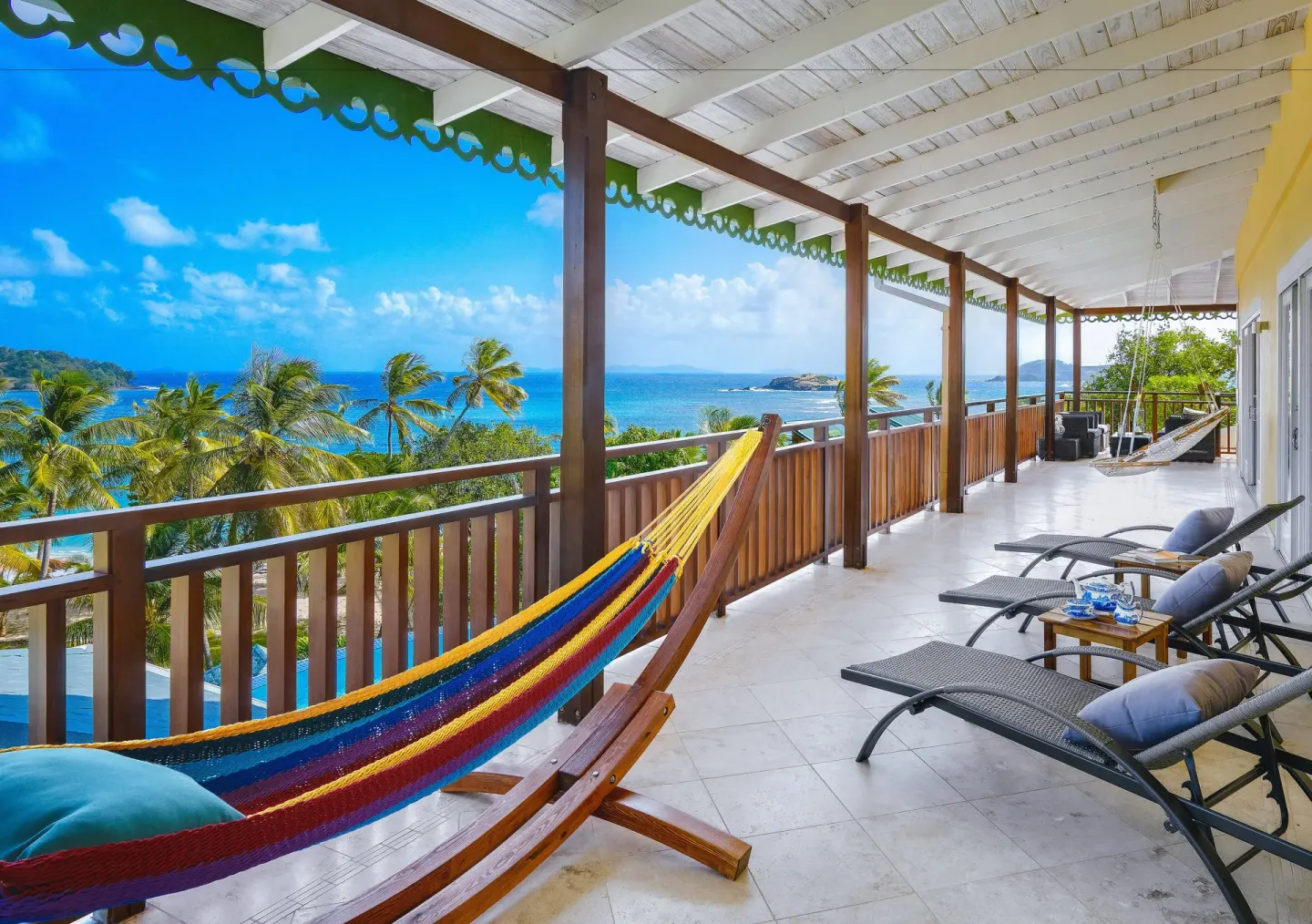 Grand Villa balcony with hammock, loungers and sea view at Bequia Beach Hotel.