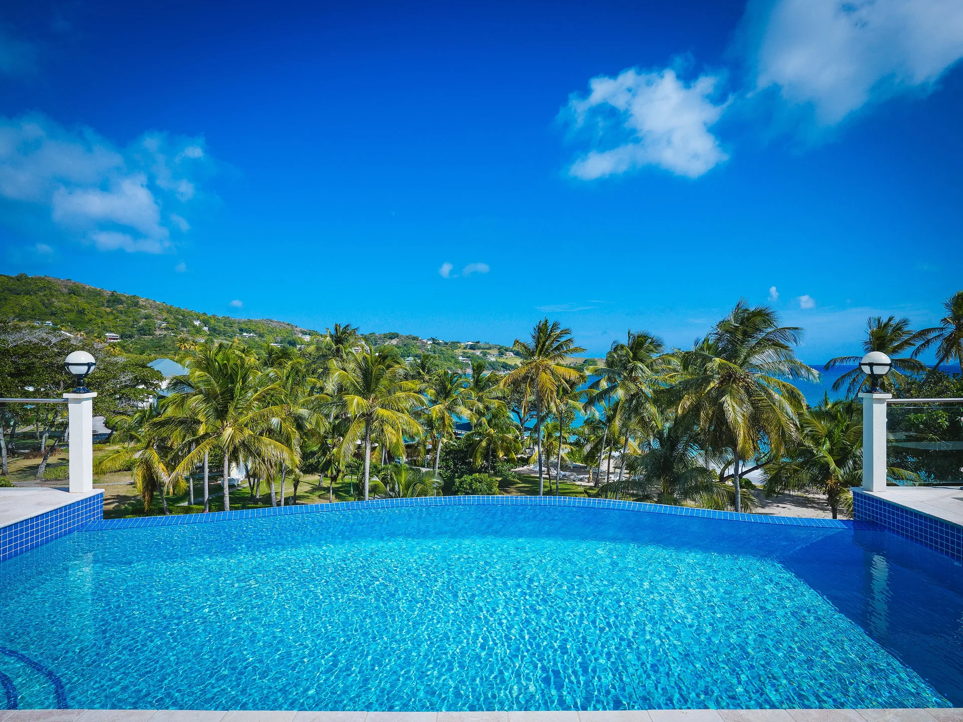 Grand Villa pool with palm and ocean views at Bequia Beach Hotel.