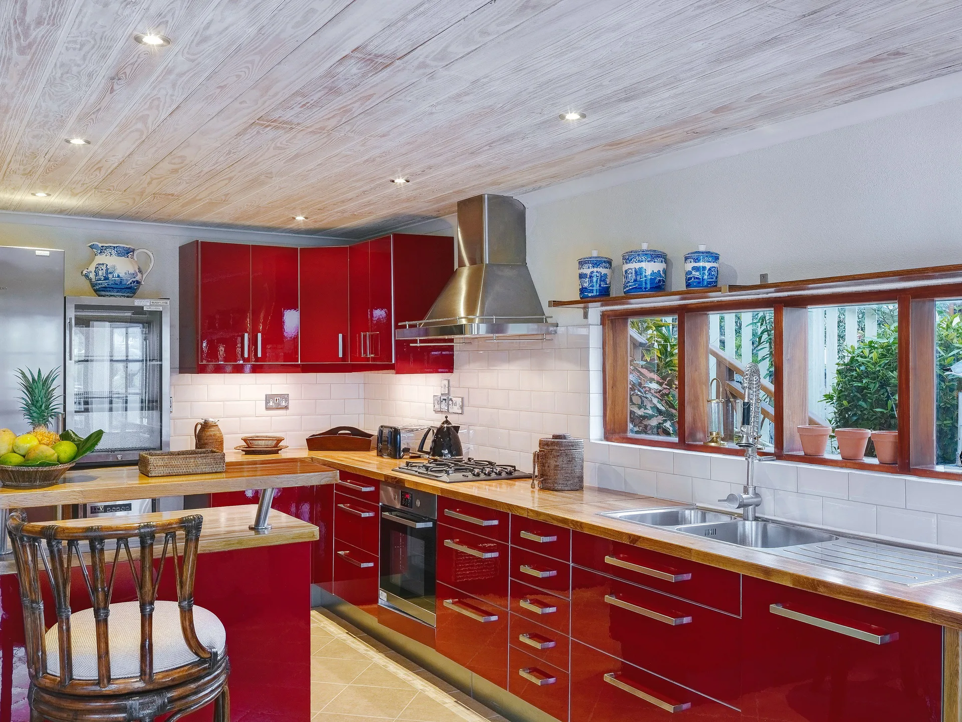 Grand Villa red kitchen with sink, cooktop and island at Bequia Beach Hotel.