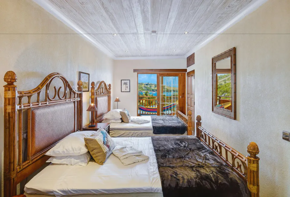 Grand Villa twin bedroom with balcony and ocean view at Bequia Beach Hotel.