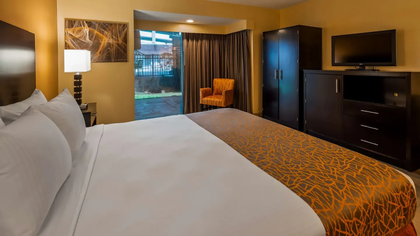King bed guest room with patio door at Best Western The Plaza Hotel Honolulu Airport.