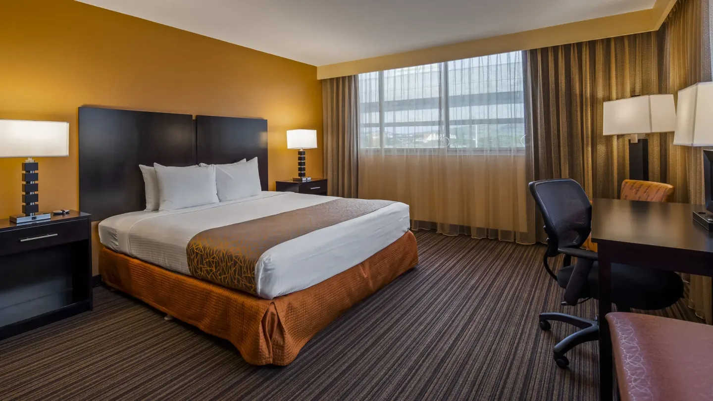 King bed guest room with window and desk at Best Western The Plaza Hotel Honolulu Airport.