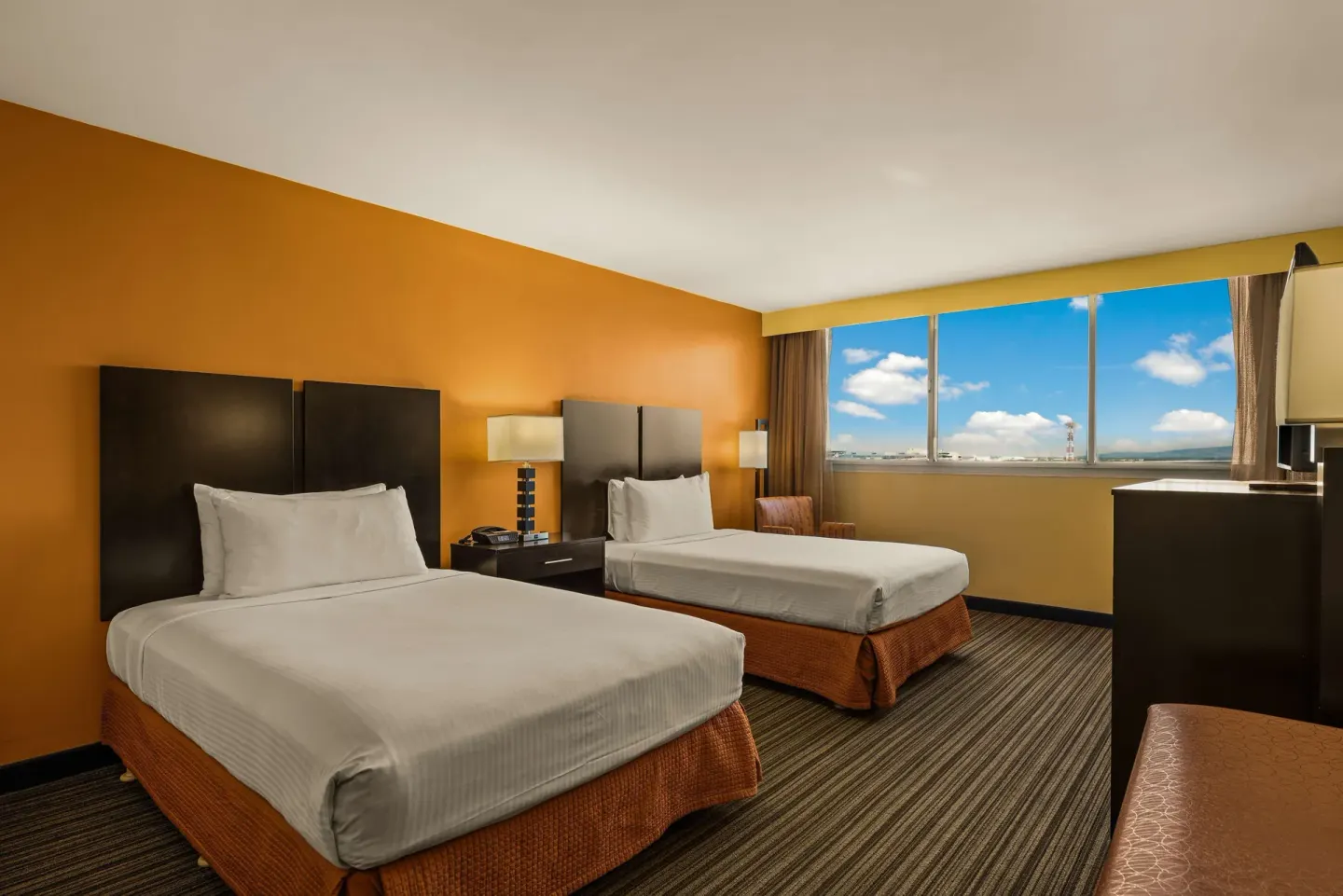 Two-bed guest room with wide window at Best Western The Plaza Hotel Honolulu Airport.