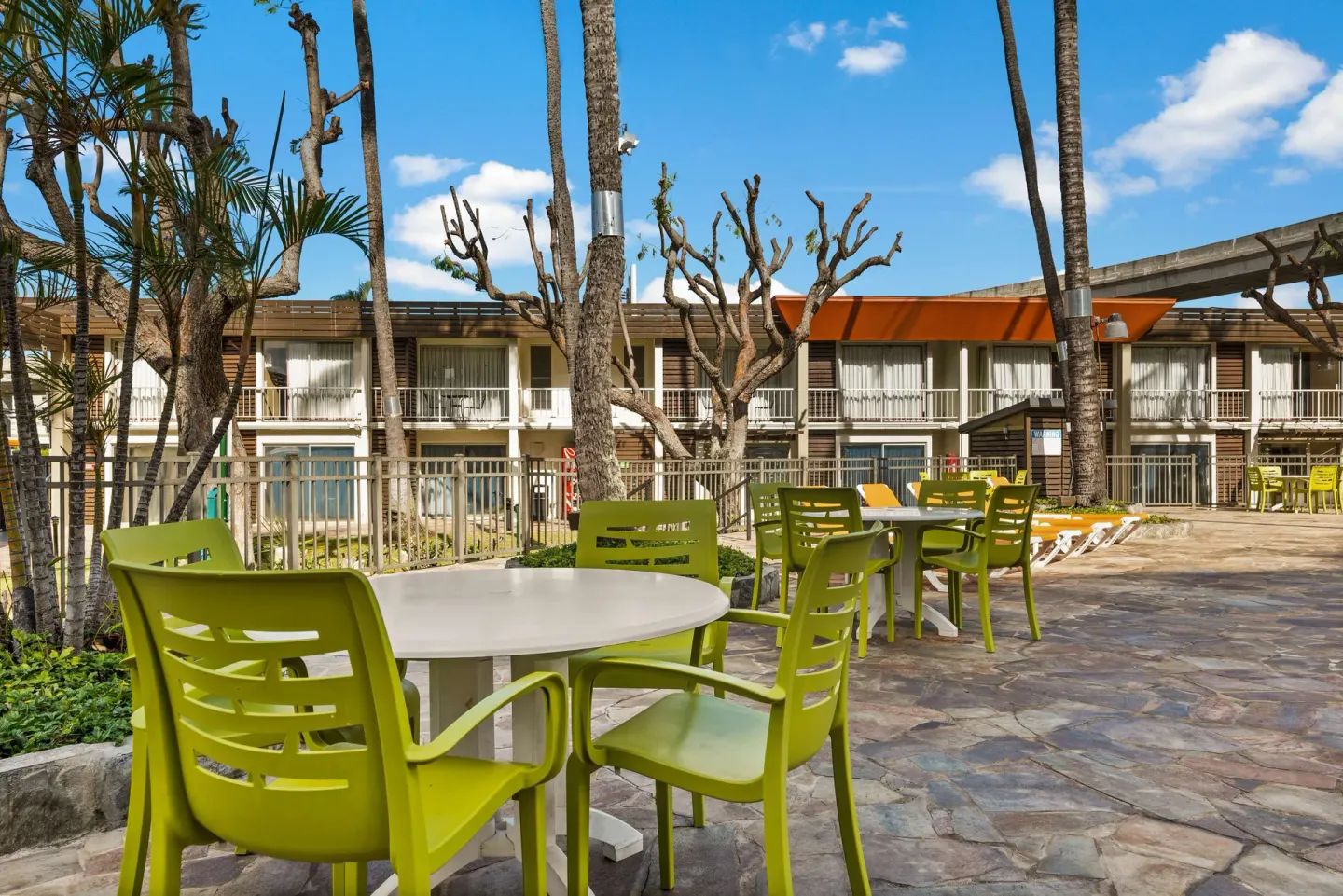 Outdoor patio tables by guest room buildings at Best Western The Plaza Hotel Honolulu Airport.