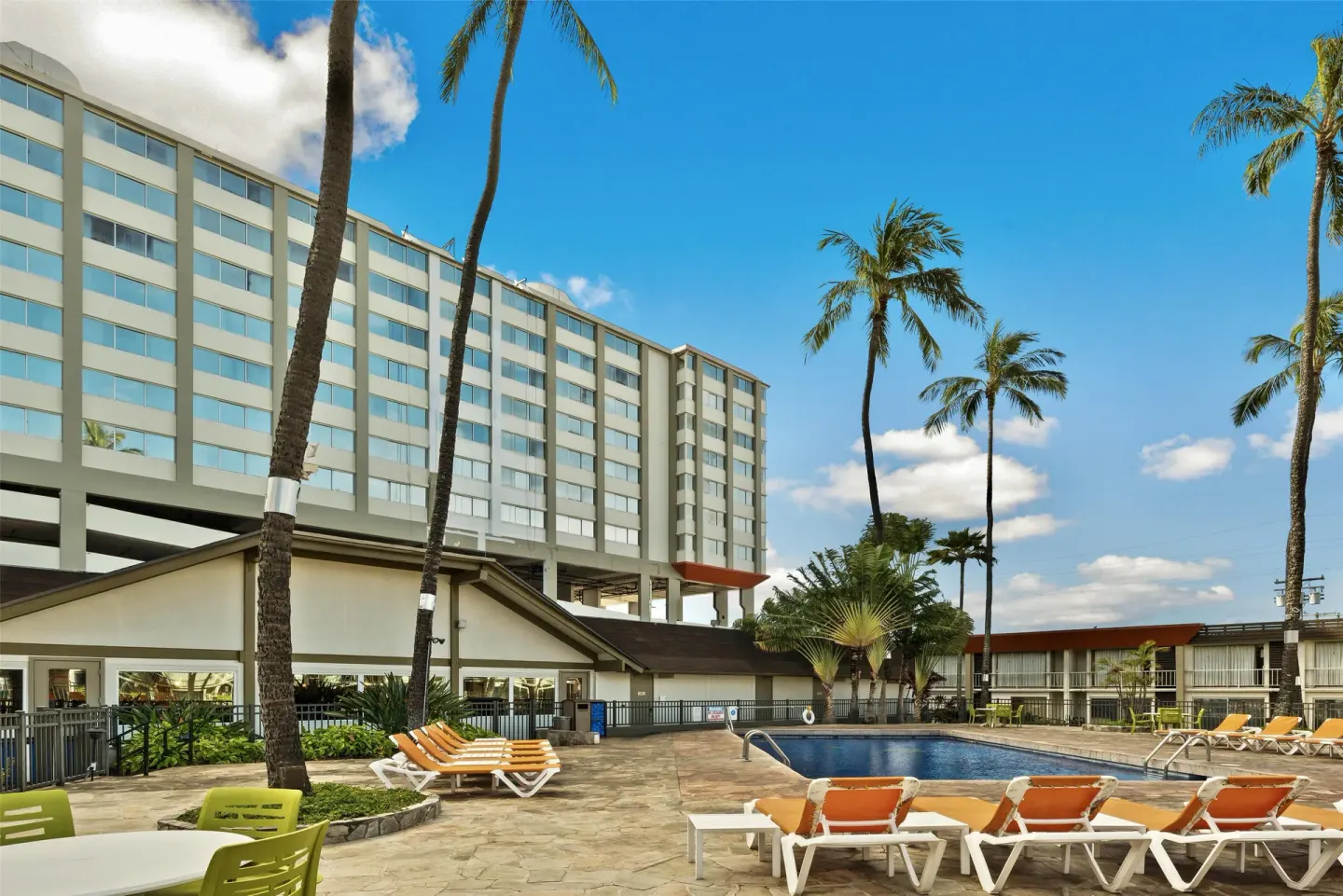 Pool courtyard with lounge chairs and palms at Best Western The Plaza Hotel Honolulu Airport.