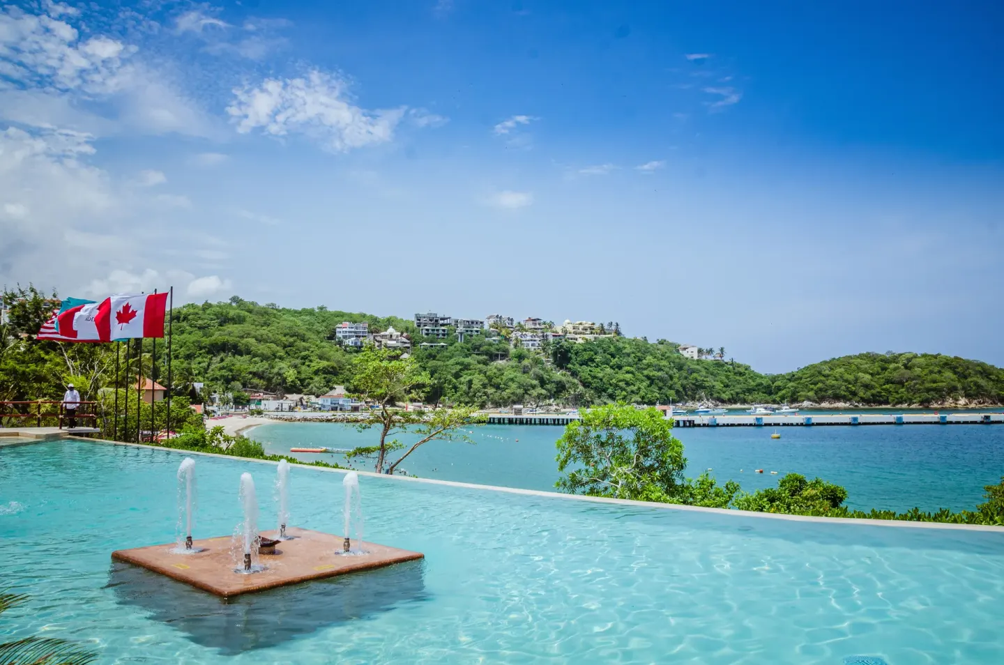 Infinity pool with bay and hillside views at Binniguenda Huatulco & Beach Club.