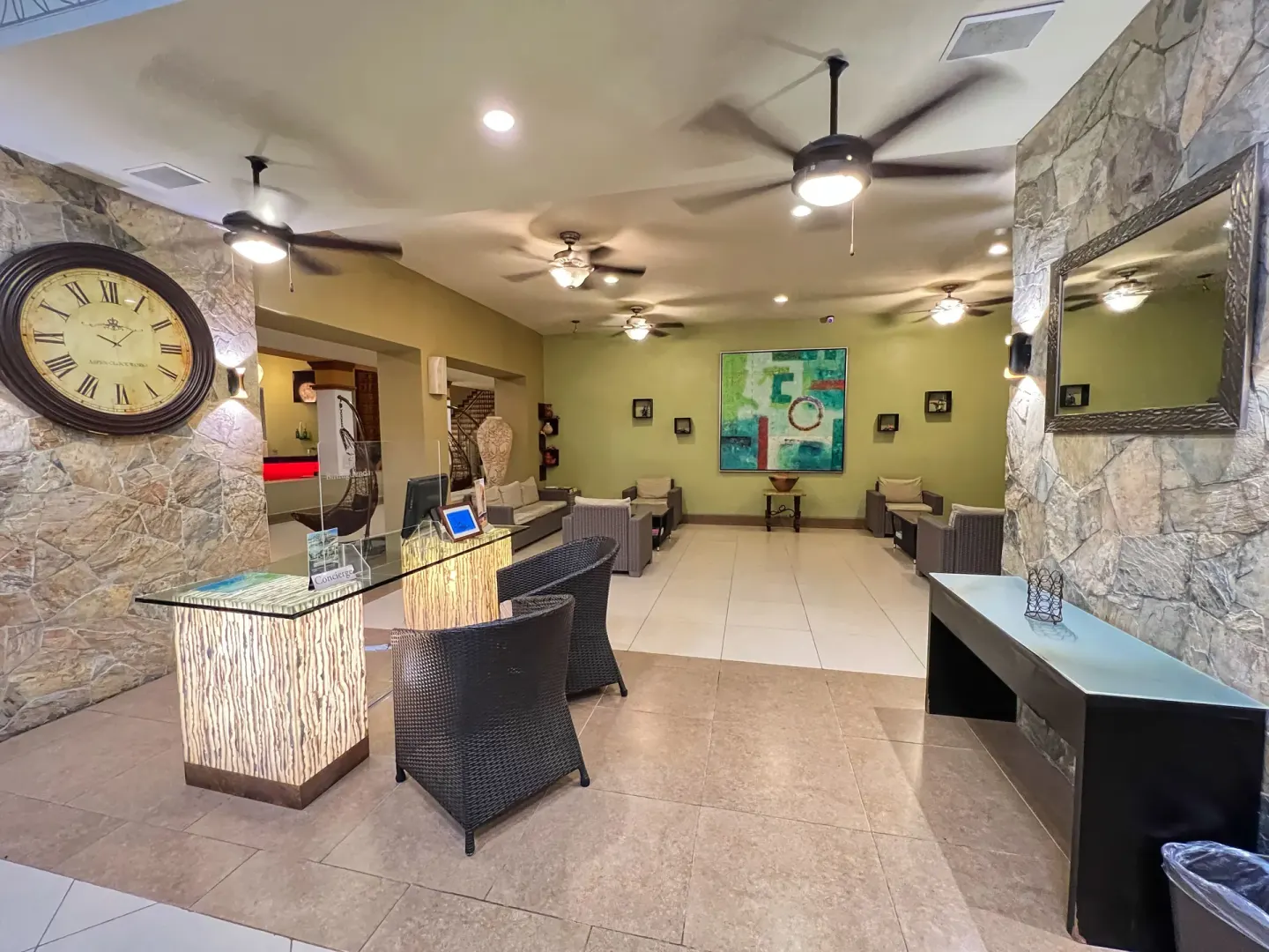 Lobby lounge with stone walls and concierge desk at Binniguenda Huatulco & Beach Club.