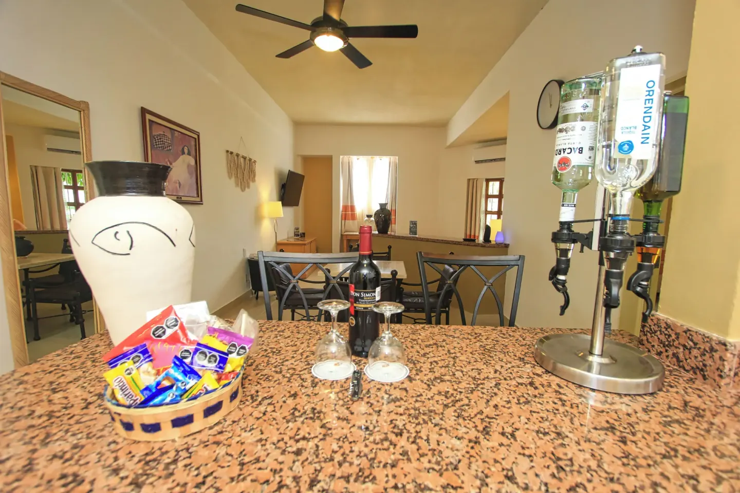 Suite bar counter at Binniguenda Huatulco & Beach Club with drinks, snacks, and a dining area beyond.