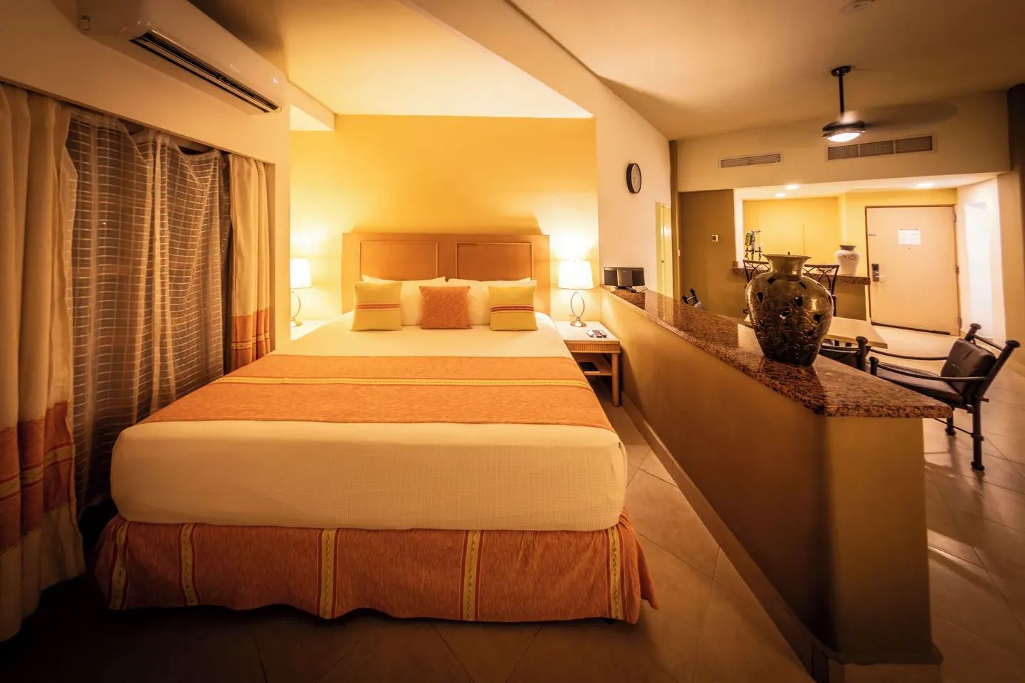 King bed suite at Binniguenda Huatulco & Beach Club with a bar counter and dining area behind it.