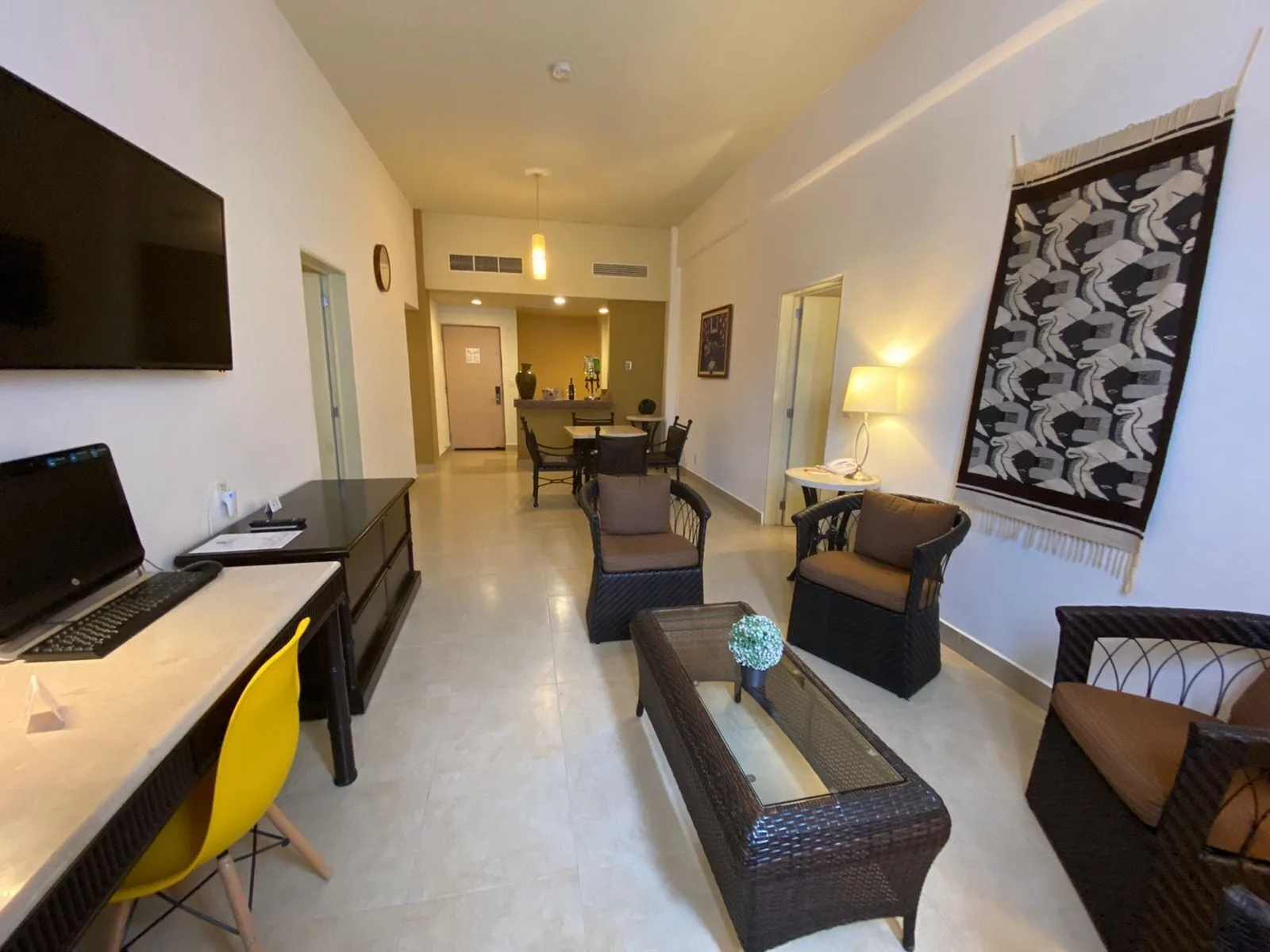 Suite living room with desk, TV, and wicker seating at Binniguenda Huatulco & Beach Club.
