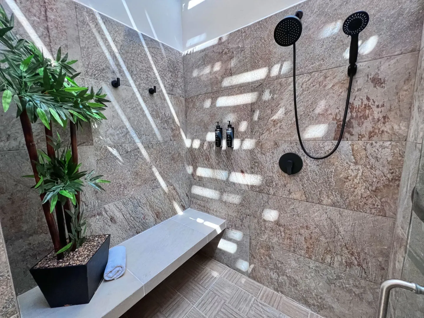 Walk-in shower with stone tile and bench at Binniguenda Huatulco & Beach Club.