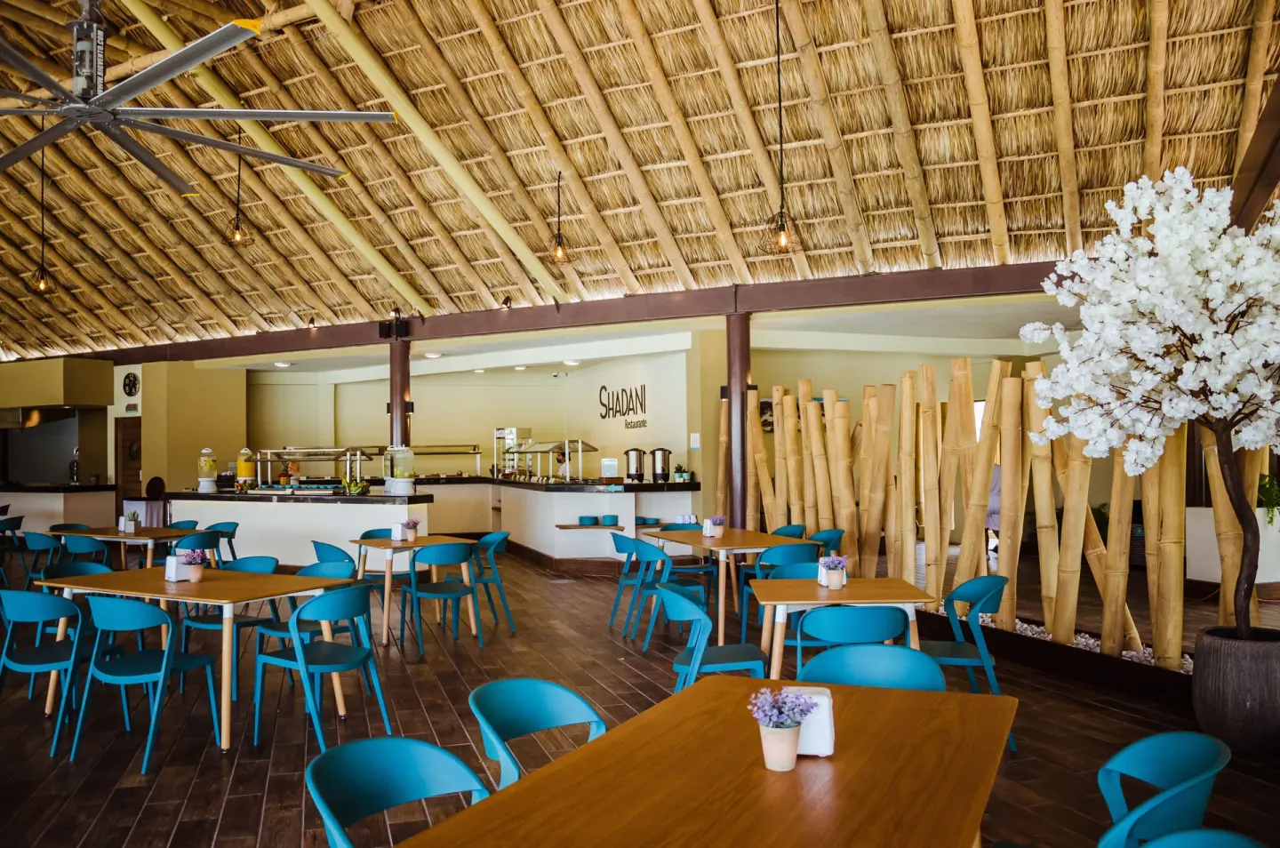 Buffet dining room with thatched ceiling and bamboo decor at Binniguenda Huatulco & Beach Club.