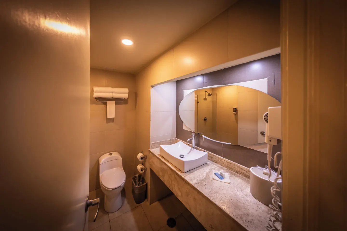 Standard Room bathroom with vanity, toilet, towels, and mirror at Binniguenda Huatulco & Beach Club.