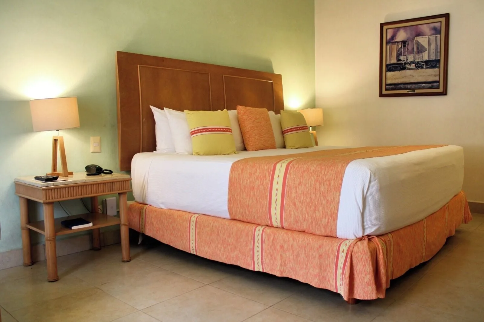 Standard Room king bed with bedside lamp and framed artwork at Binniguenda Huatulco & Beach Club.