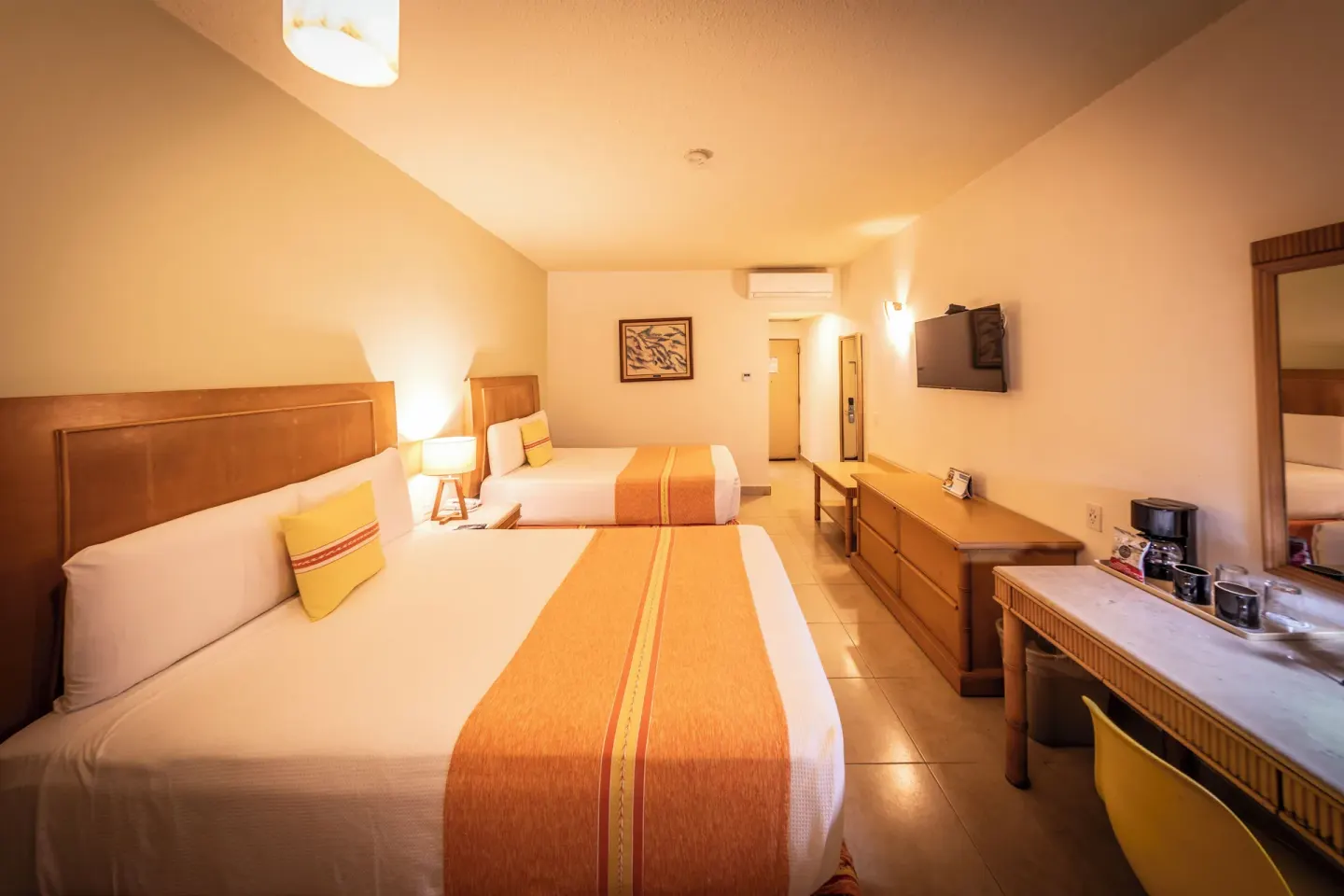 Standard Room with two beds, dresser, TV, and desk at Binniguenda Huatulco & Beach Club.