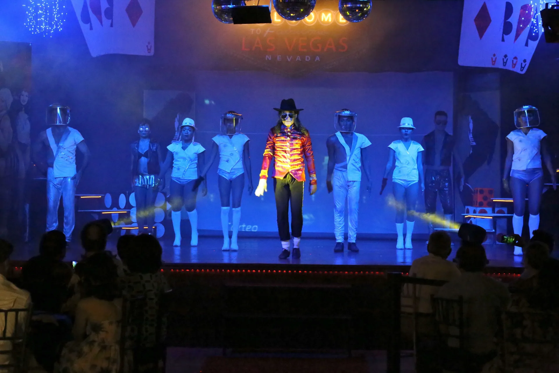 Costumed stage performers under blue lights at Binniguenda Huatulco & Beach Club.