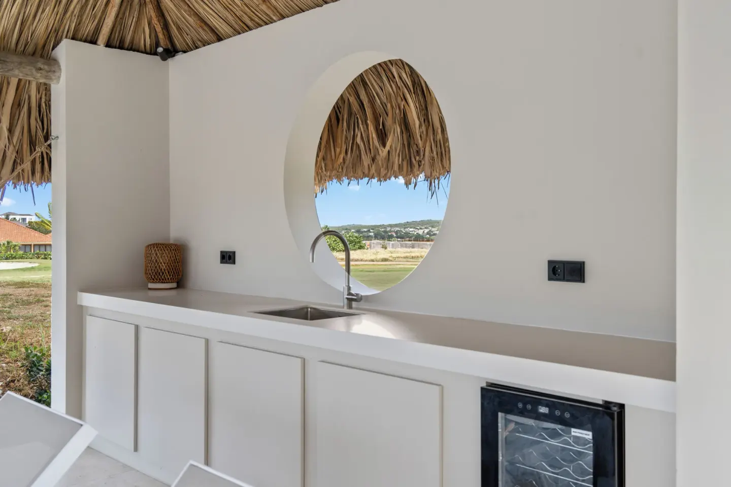 Covered outdoor kitchenette with round opening at Blue Bay Curacao Golf & Beach Resort.