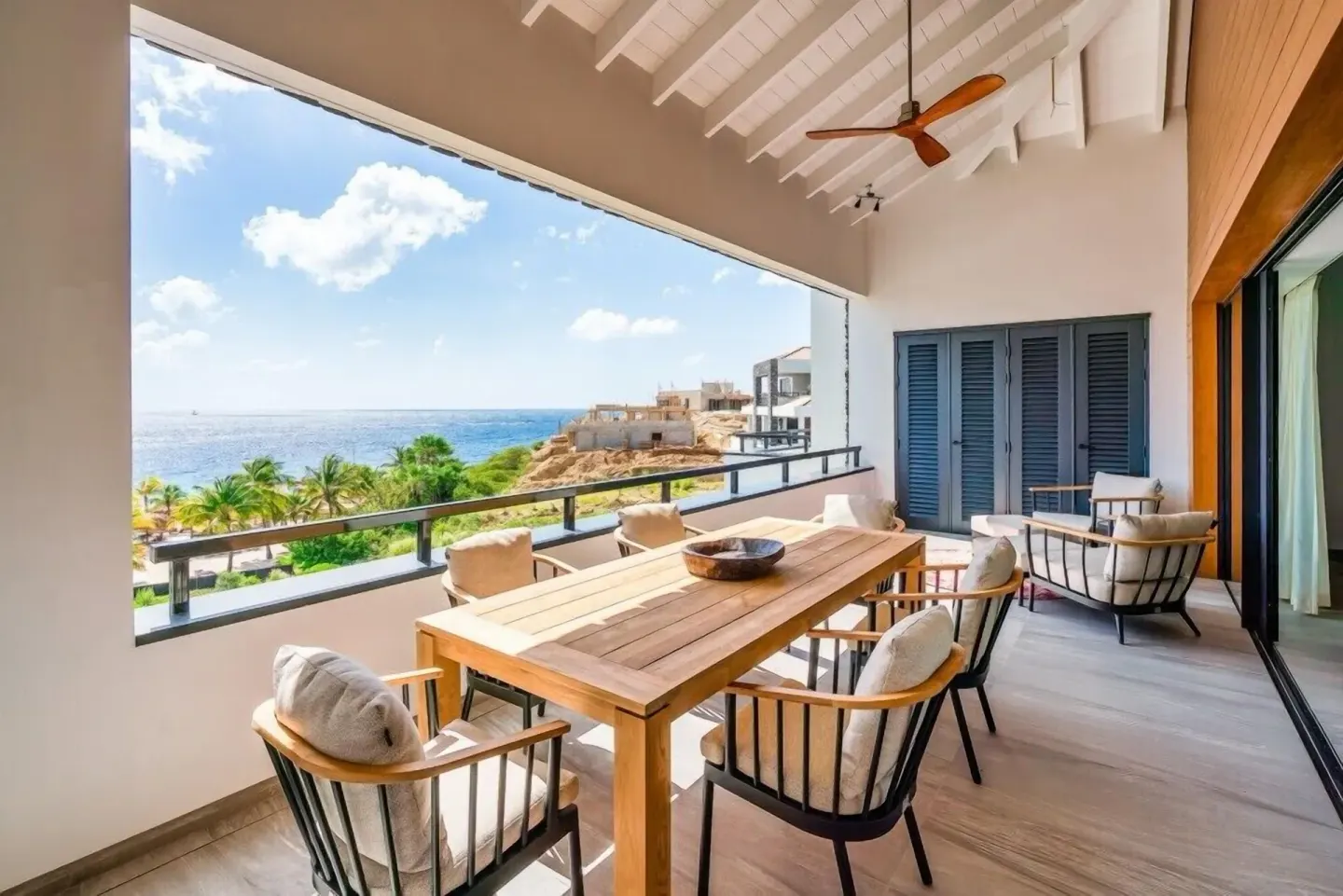 Covered terrace with dining table and ocean view at Blue Bay Curacao Golf & Beach Resort.