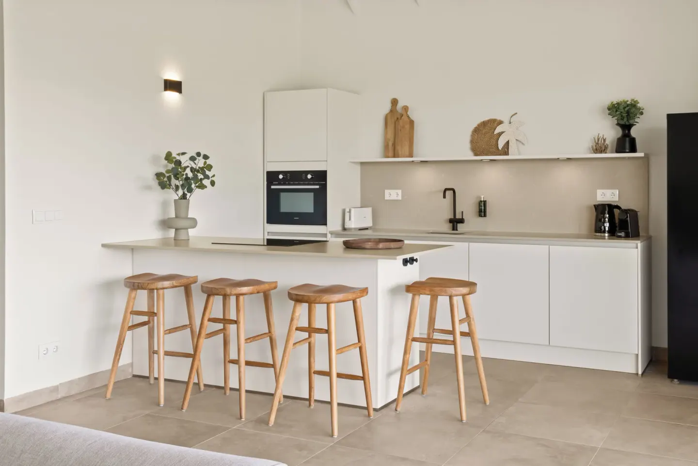White kitchenette with bar stools in a guest residence at Blue Bay Curacao Golf & Beach Resort.