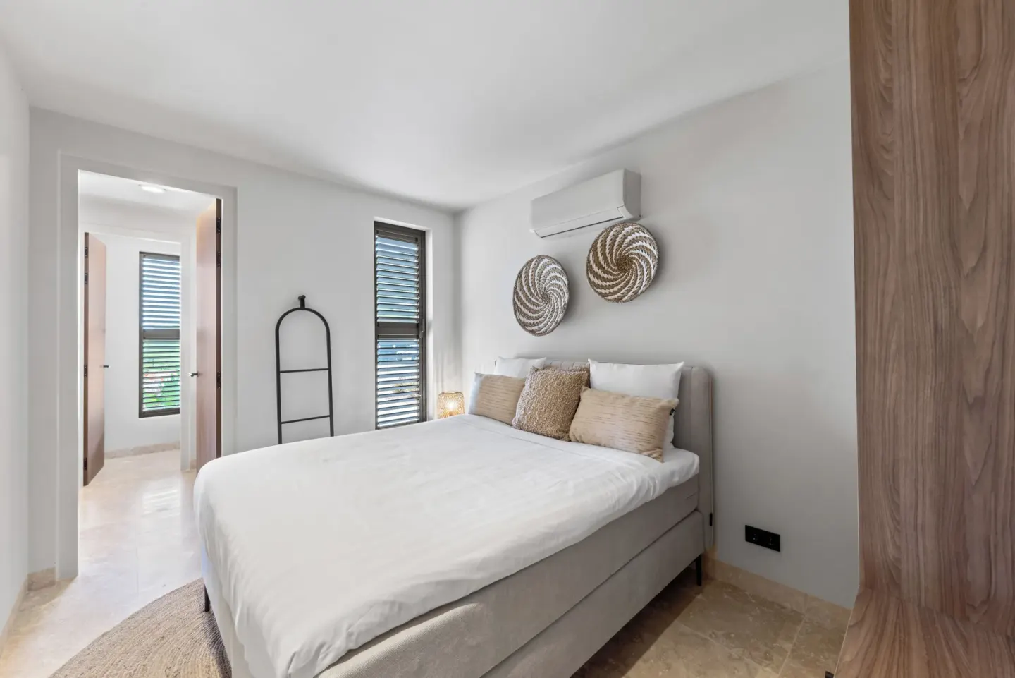 Guest room king bed with louvered windows at Blue Bay Curacao Golf & Beach Resort.