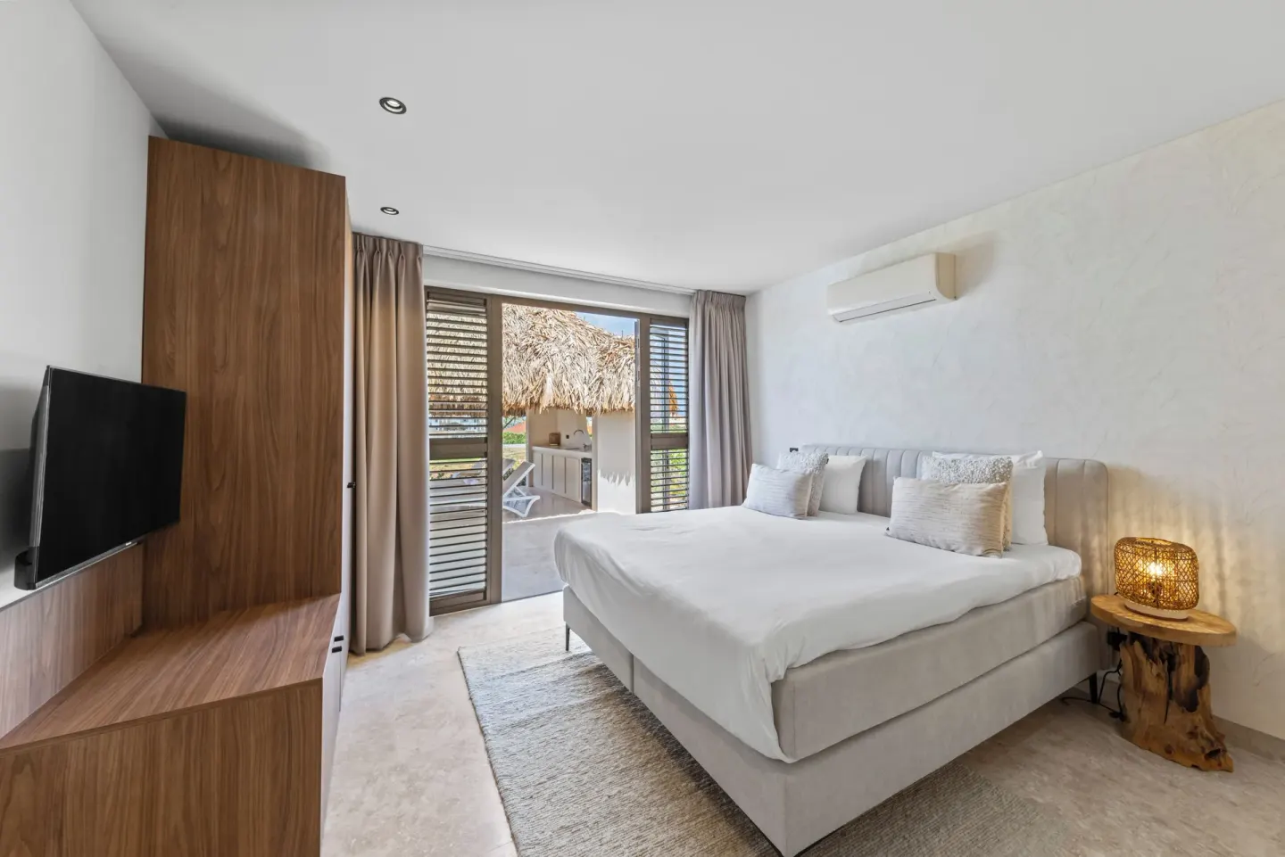 Guest room king bed with patio doors at Blue Bay Curacao Golf & Beach Resort.