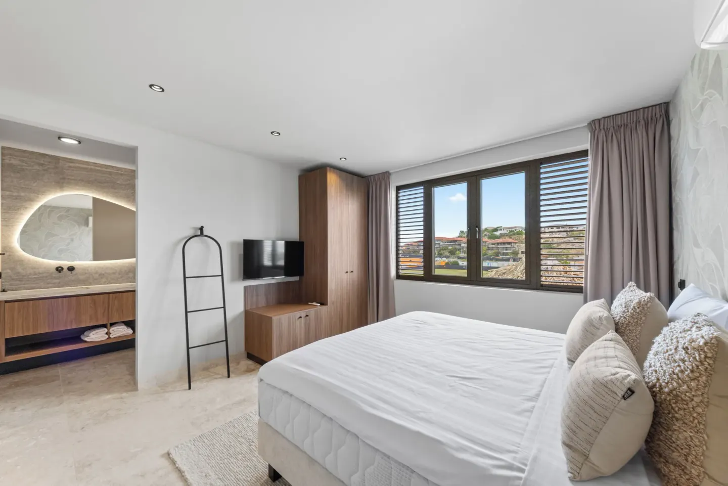 Guest room king bed with open vanity area at Blue Bay Curacao Golf & Beach Resort.