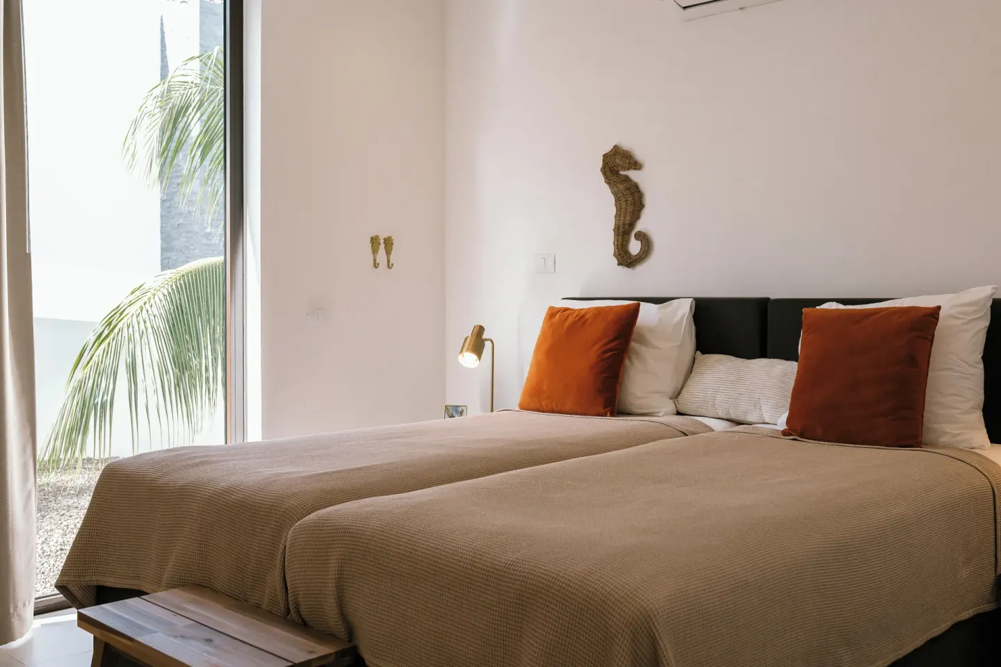Twin-bed guest room with seahorse wall decor at Blue Bay Curacao Golf & Beach Resort.