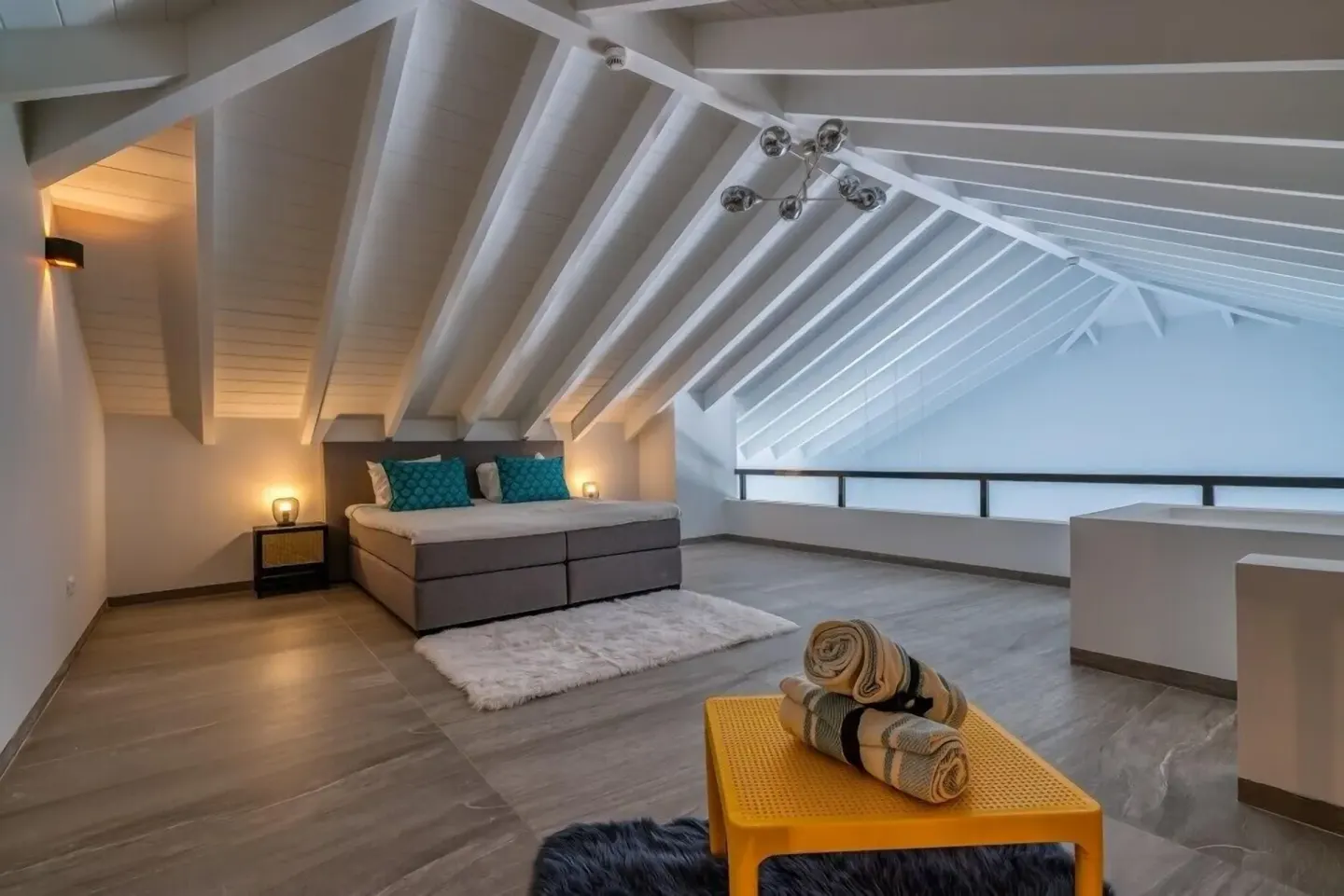 Loft guest room with bed under white rafters at Blue Bay Curacao Golf & Beach Resort.