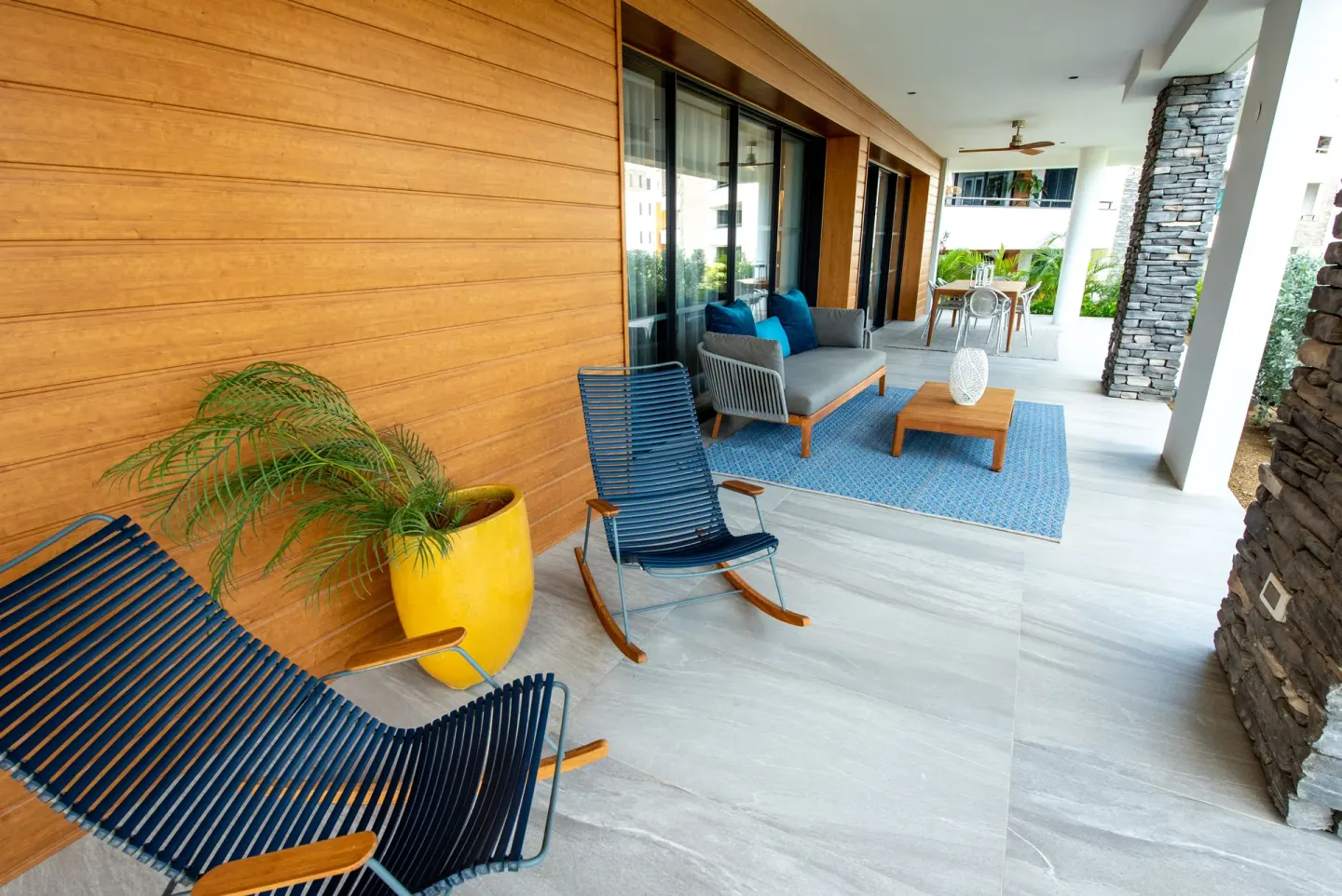 Patio with blue rocking chairs and outdoor sofa at Blue Bay Curacao Golf & Beach Resort.