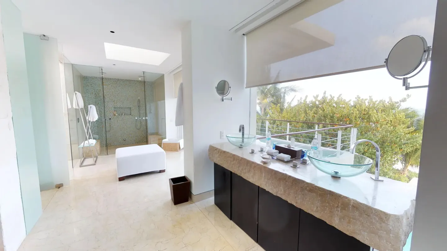 Bright bathroom with double glass sinks and balcony view at Blue Diamond Luxury Boutique.