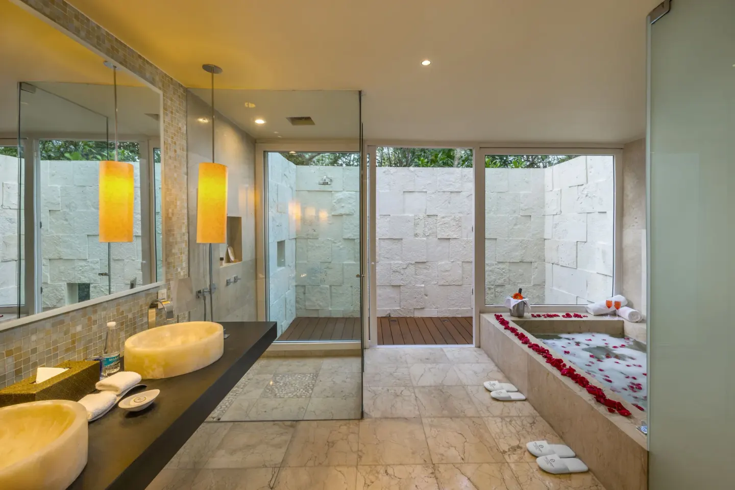 Spacious bathroom with twin sinks, shower and petal-lined tub at Blue Diamond Luxury Boutique.