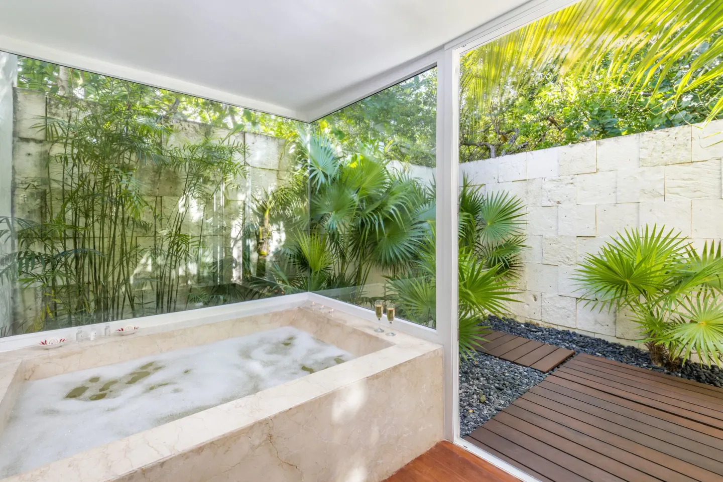 Marble soaking tub beside garden windows at Blue Diamond Luxury Boutique.