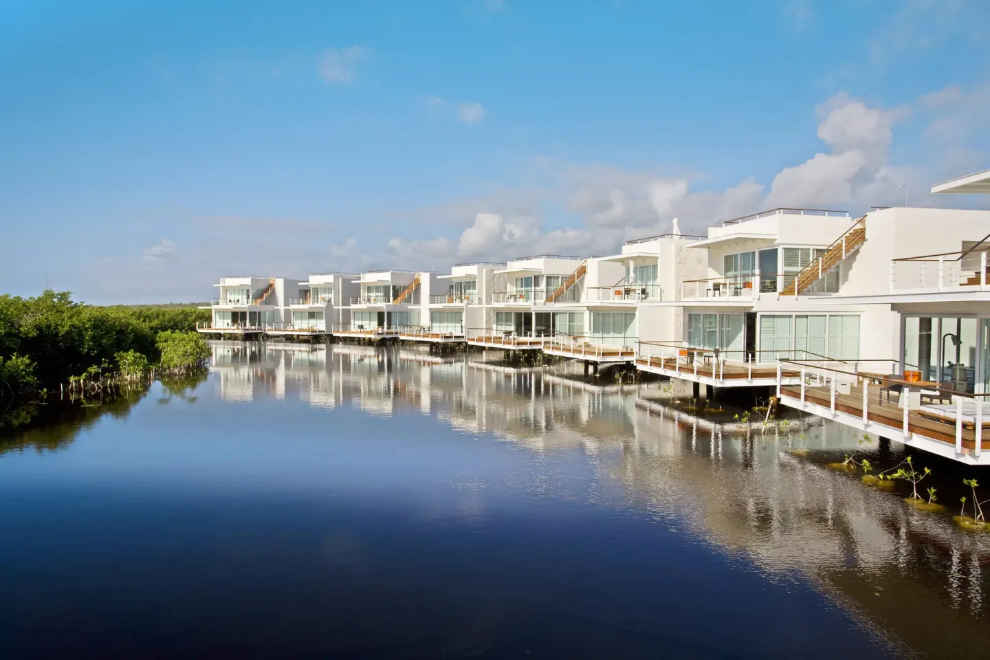 White suite buildings reflected on a lagoon at Blue Diamond Luxury Boutique.