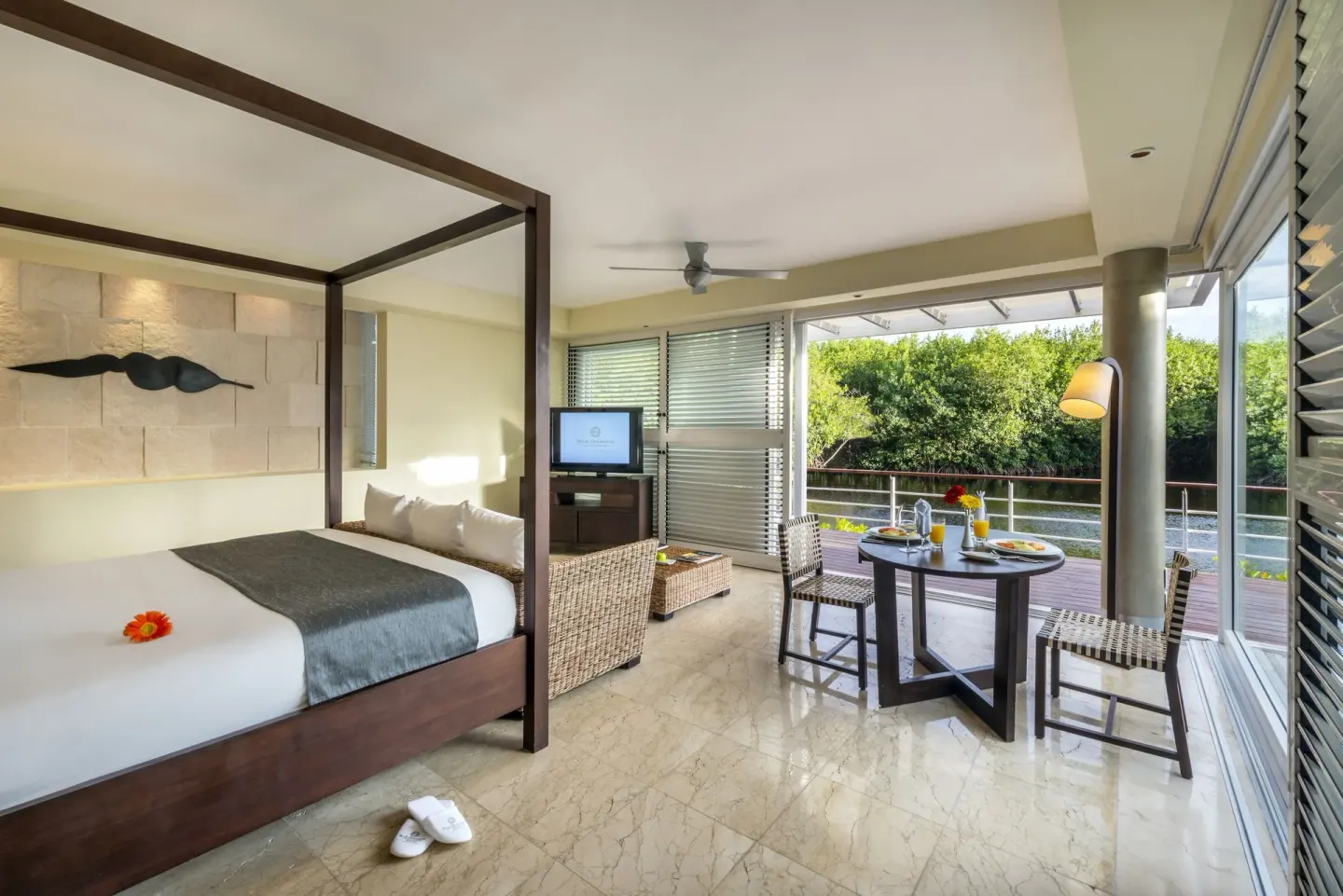 Lagoon-view suite with four-poster bed and balcony at Blue Diamond Luxury Boutique.
