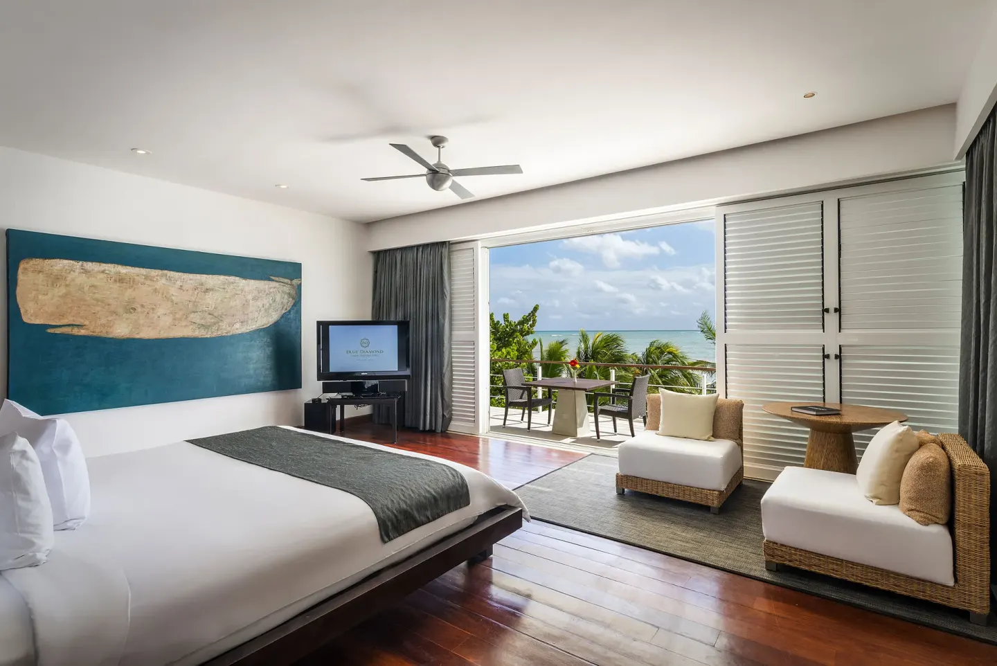 Ocean-view guest room with king bed and terrace at Blue Diamond Luxury Boutique.