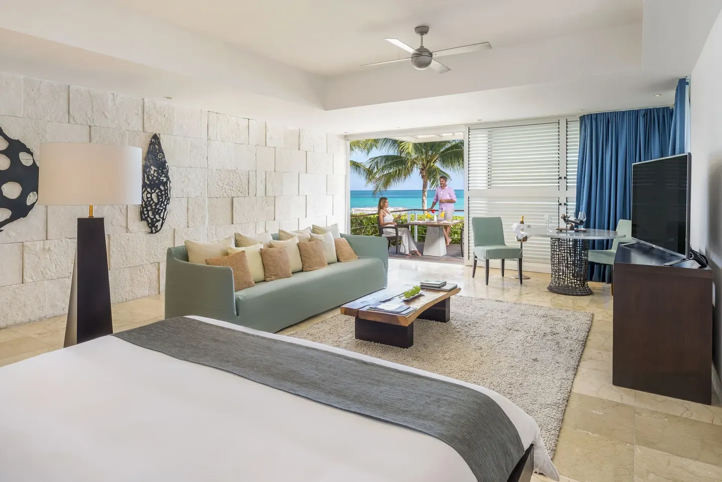 Ocean-view suite with bed, sofa, and balcony at Blue Diamond Luxury Boutique.