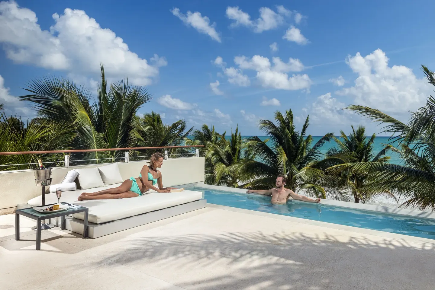 Oceanfront terrace pool at Blue Diamond Luxury Boutique with guests relaxing by the water.
