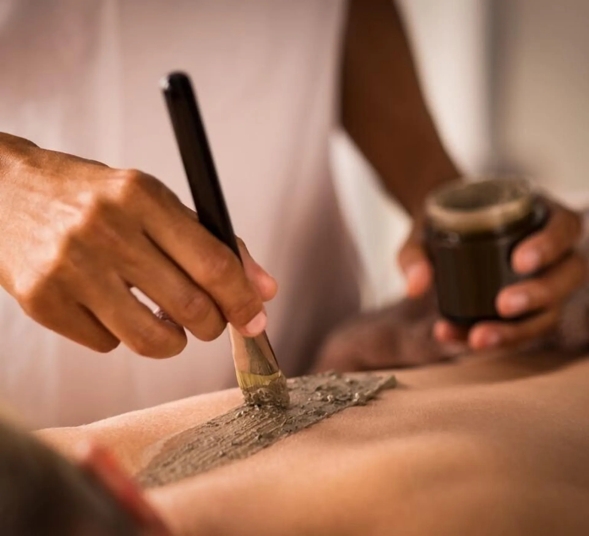 A spa therapist applies a body treatment at Blue Diamond Luxury Boutique.