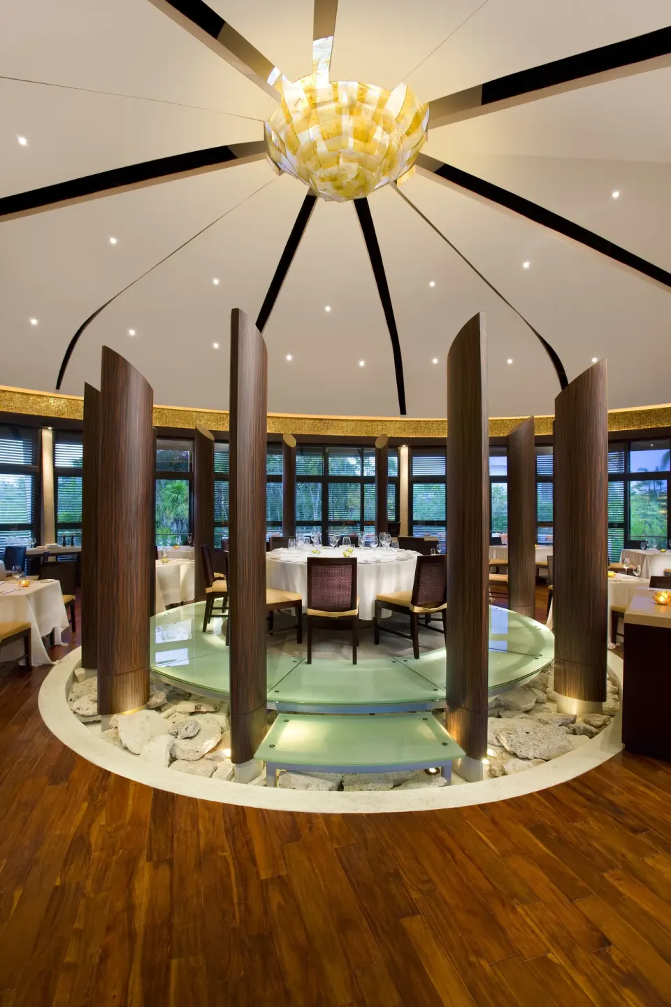 Circular dining room with wood columns and set tables at Blue Diamond Luxury Boutique.