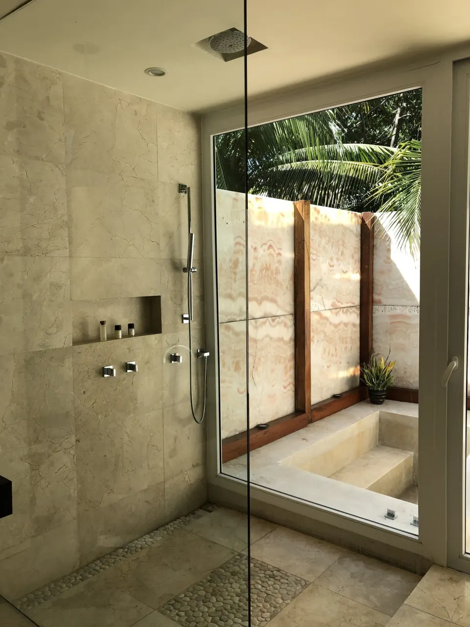 Marble shower and windowed bath area in a suite at Blue Diamond Luxury Boutique.