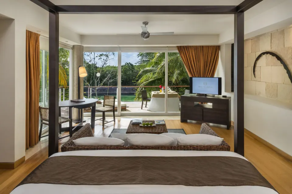 Cenote Lagoon Deluxe Junior Suite king bed facing balcony at Blue Diamond Luxury Boutique.