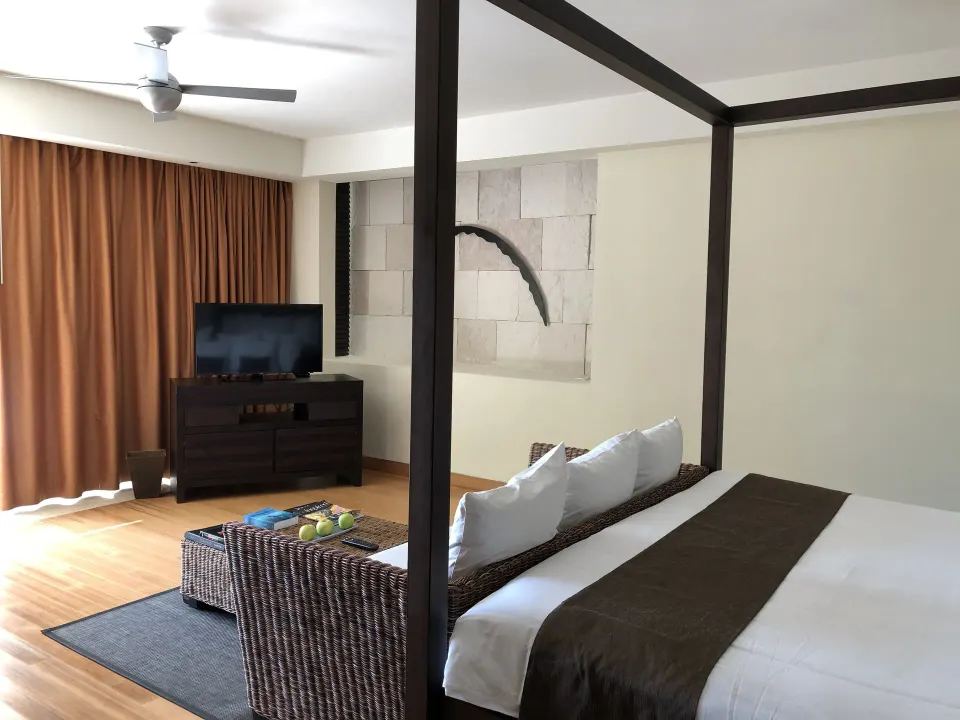 Cenote Lagoon Deluxe Junior Suite king bed with TV area at Blue Diamond Luxury Boutique.