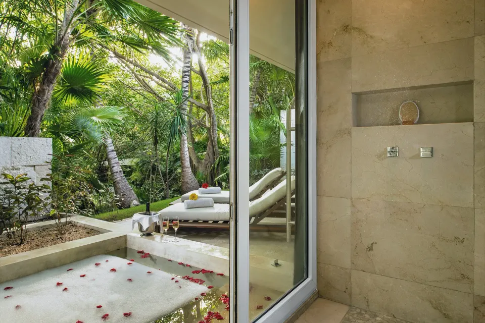 Junior Suite patio at Blue Diamond Luxury Boutique with garden view, loungers, and stone shower wall.