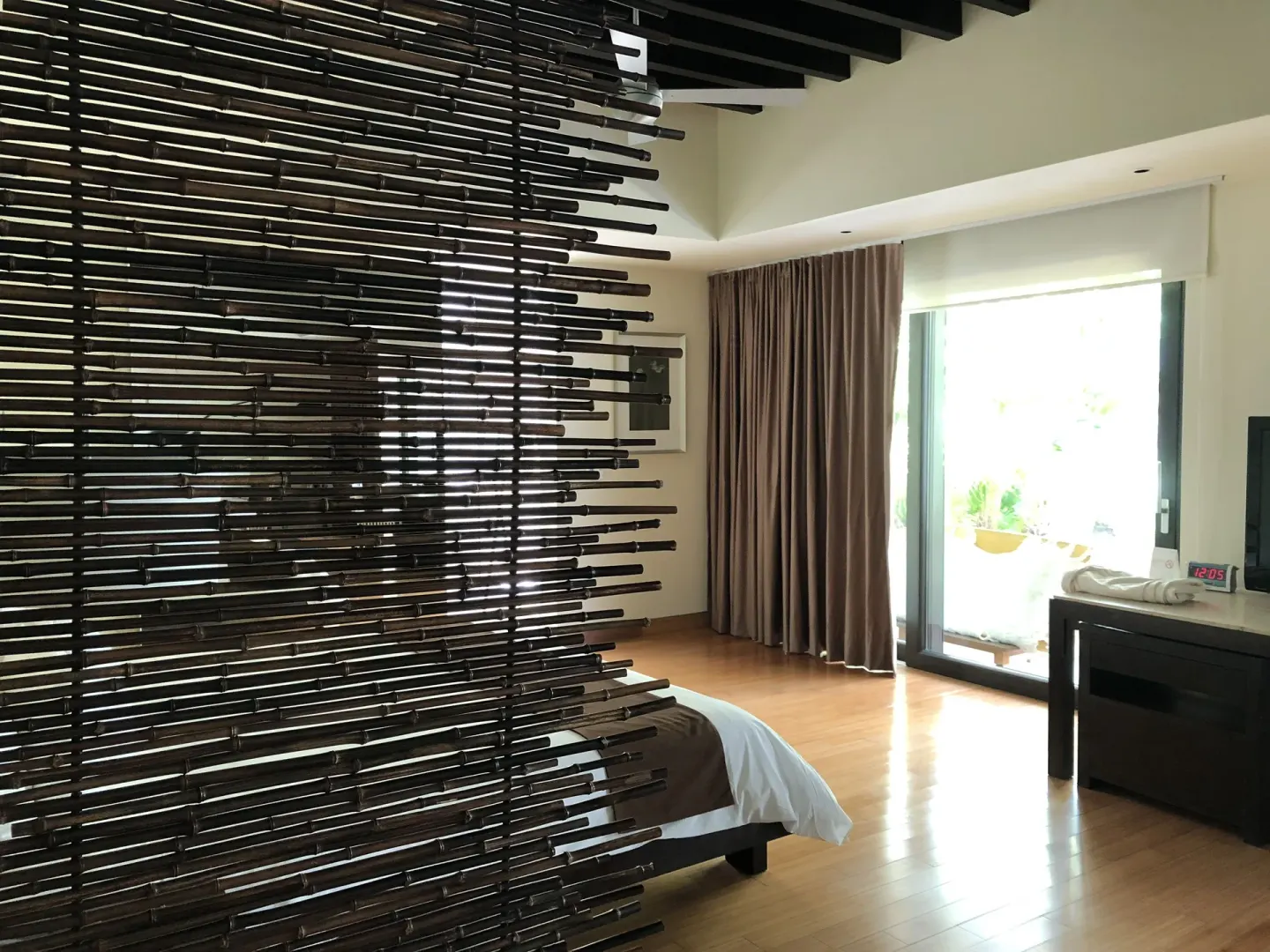 Junior Suite bedroom at Blue Diamond Luxury Boutique with a slatted screen and bright patio doors.