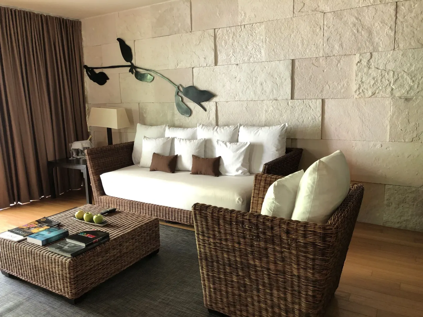 Junior Suite lounge at Blue Diamond Luxury Boutique with wicker sofa, chair, and stone wall.