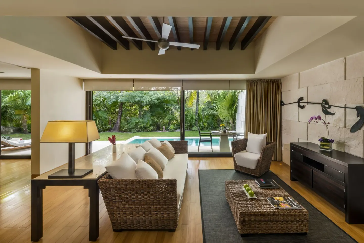 Patio Diamond Suite living room with wicker seating and pool view at Blue Diamond Luxury Boutique.
