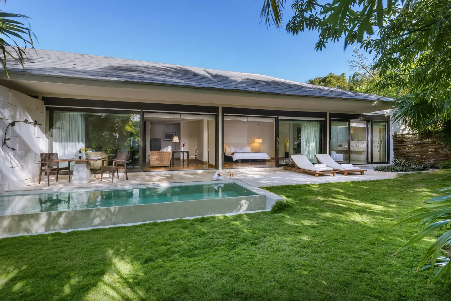 Patio Diamond Suite exterior with lawn, pool, patio, and bed visible at Blue Diamond Luxury Boutique.
