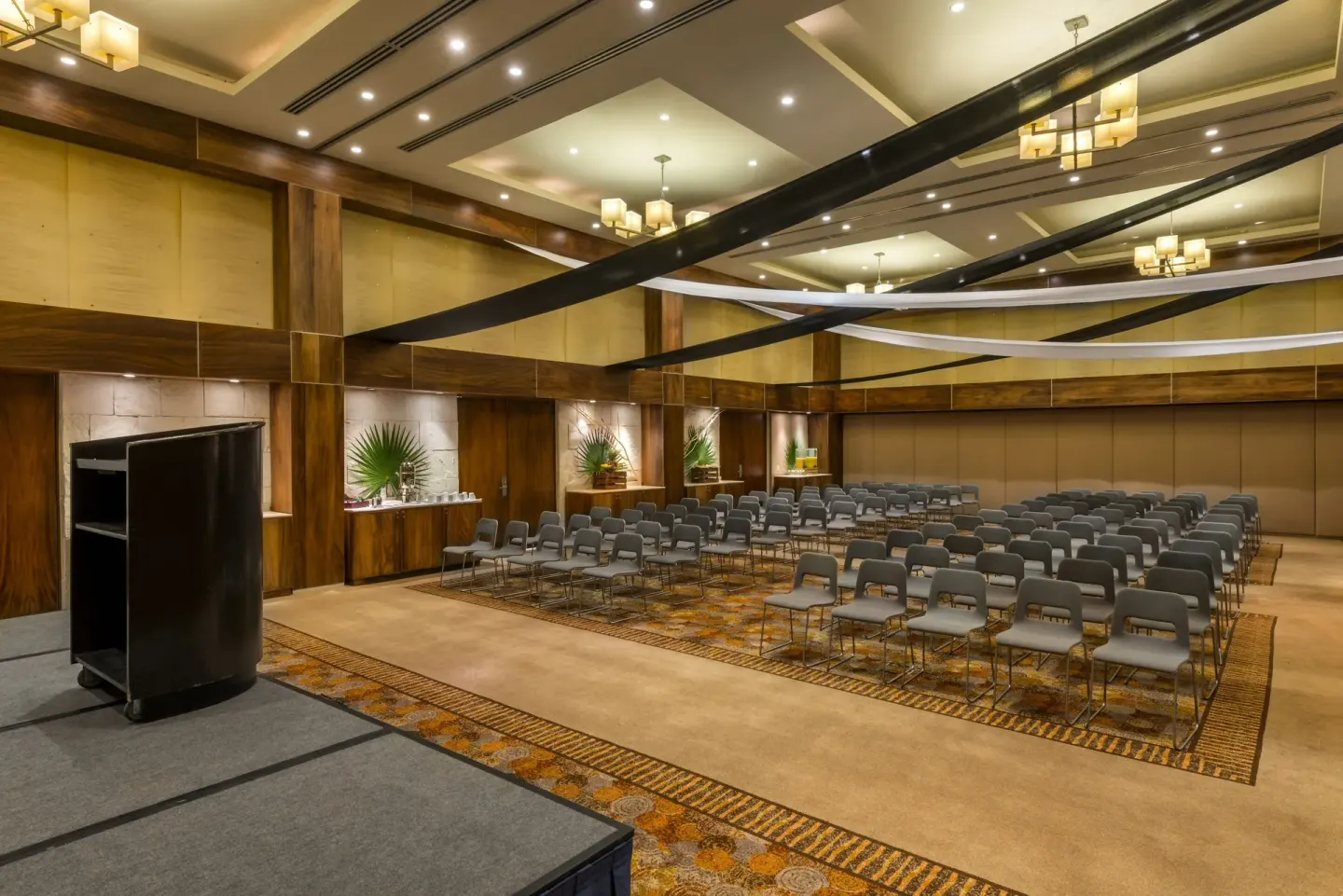 Conference room with rows of chairs and a stage at Blue Diamond Luxury Boutique.