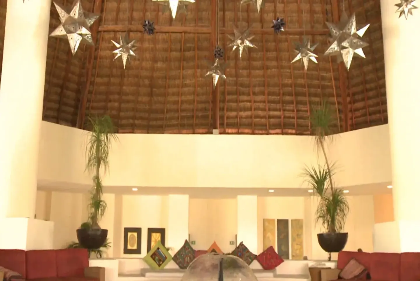 Lobby seating under a tall thatched ceiling at BlueBay Grand Esmeralda.